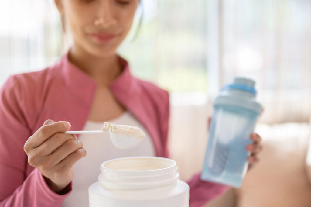 una mujer tomando creatina monohidrato con su coctelera